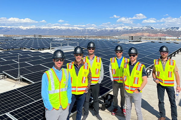 Great Basin Ventures employees standing in front of rows of rooftop solar panels